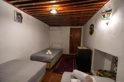 a room with two beds and a couch in it at RIAD DAR DIWAN in Fès