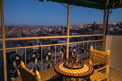a table on a balcony with a view of a city at RIAD DAR DIWAN in Fès
