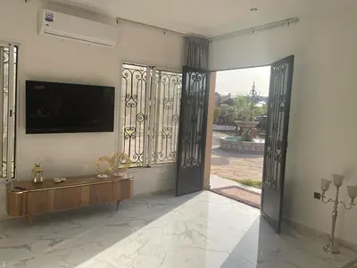 a living room with a tv and a large door at Amazing house separate of Villa with Swimming Pool in Marrakech