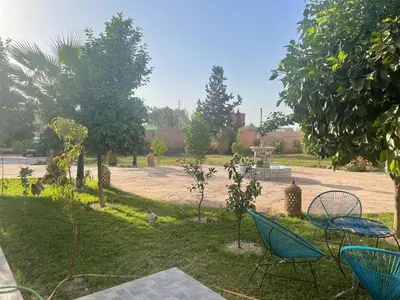a yard with chairs and trees and a courtyard at Amazing house separate of Villa with Swimming Pool in Marrakech