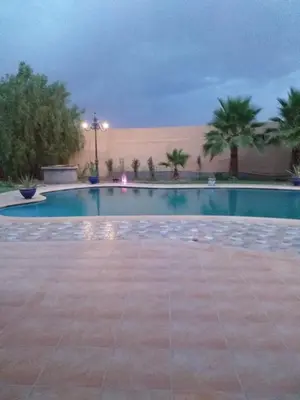 a swimming pool with palm trees and a building at Amazing house separate of Villa with Swimming Pool in Marrakech