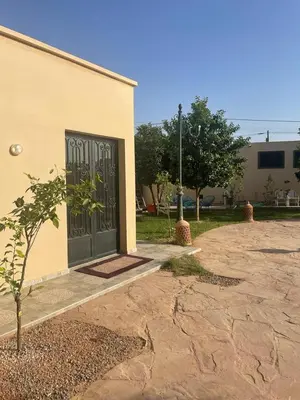 a building with a black door with a tree in front at Amazing house separate of Villa with Swimming Pool in Marrakech
