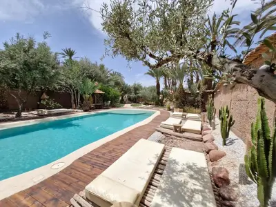 a swimming pool with chaise lounges and a cactus at L'Ma Lodge in Skoura