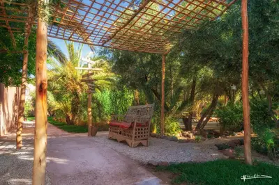 a wooden bench sitting under a pergola at L'Ma Lodge in Skoura