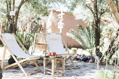 two lawn chairs and a table with candles on it at L'Ma Lodge in Skoura