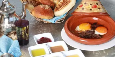 a table with a bowl of food and some bread at شقق للكراء اليومي بالرشيدية Errachidia in Er Rachidia