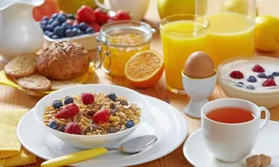 a breakfast table with a bowl of cereal and a cup of coffee at شقق للكراء اليومي بالرشيدية Errachidia in Er Rachidia