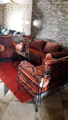a bedroom with a bed with a table and a couch at شقق للكراء اليومي بالرشيدية Errachidia in Er Rachidia