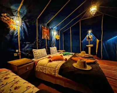 a bedroom with two beds with hats on them at Merzouga Nomad Camp in Merzouga