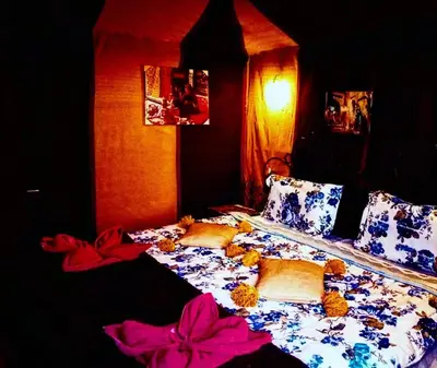 a bedroom with a bed with flowers on it at Rachid Luxury Camp in Merzouga