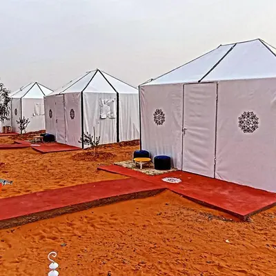 a row of white tents in the desert at Rachid Luxury Camp in Merzouga