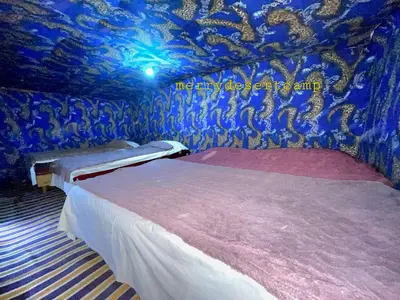 a room with two beds and a blue ceiling at Merry Desert Camp in Merzouga
