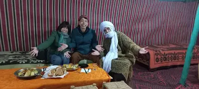 a group of people sitting on a couch with a table at Merry Desert Camp in Merzouga
