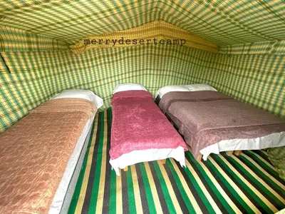 three beds in a green tarped room at Merry Desert Camp in Merzouga