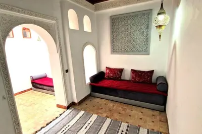 a red couch in a room with two windows at Entire Private House in Fez Medina! in Fès
