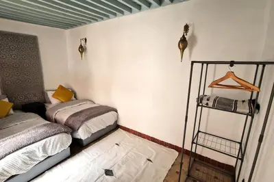 a room with two beds and a shelf in it at Entire Private House in Fez Medina! in Fès
