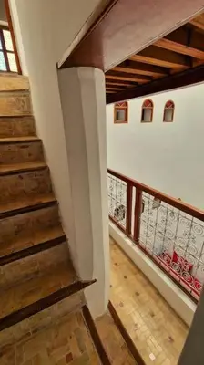 a stairway in a house with a wooden railing at Entire Private House in Fez Medina! in Fès