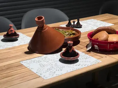 a wooden table with food and a pot on it at Villa Naouma in Marrakech
