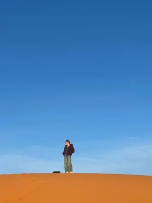 a man standing in the middle of a desert at Desert Bliss Luxury Camp in Merzouga