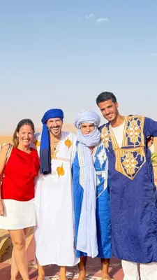 a group of people dressed in costumes posing for a picture at Desert Bliss Luxury Camp in Merzouga