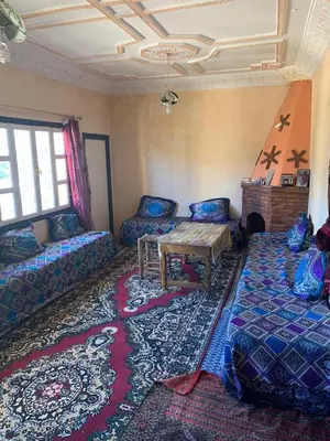 a living room with couches and a table and a rug at Maison d'hôtes au pied du grand Atlas- Asguine- Ourika in Asguine