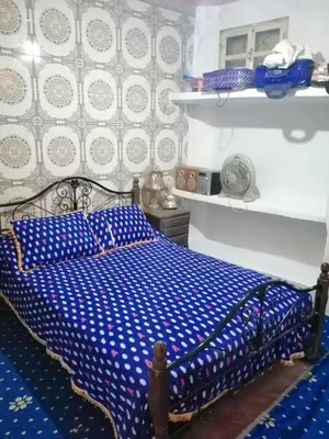 a bedroom with a bed with a blue and white comforter at Maison d'hôtes au pied du grand Atlas- Asguine- Ourika in Asguine