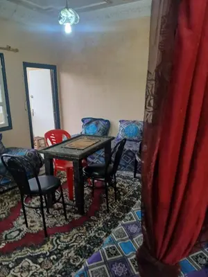 a room with chairs and a table with a red curtain at Maison d'hôtes au pied du grand Atlas- Asguine- Ourika in Asguine
