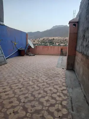 an empty courtyard of a building with mountains in the background at Maison d'hôtes au pied du grand Atlas- Asguine- Ourika in Asguine