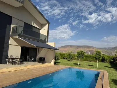 a house with a swimming pool in the yard at Villa Deluxe Au Pied de l'Atlas Béni Mellal in Ksar et Tlatia