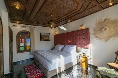 a bedroom with a large bed with a red headboard at DARIF's Riad & Spa in Fès
