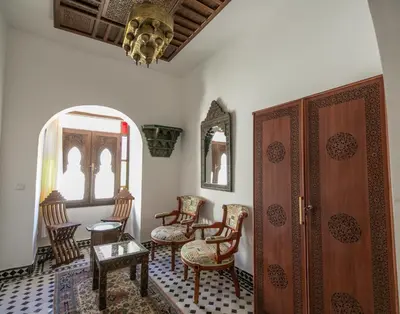 a room with chairs and a door and a table at DARIF's Riad & Spa in Fès