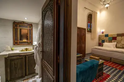 a bathroom with a sink and a bedroom with a bed at DARIF's Riad & Spa in Fès
