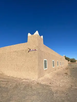 a large building in the middle of the desert at DAR MIRA DUNES Hassilabiad-Merzouga in Hassilabied