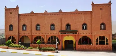 a large red brick building with two entrances at Hotel Almanader in Boumalne