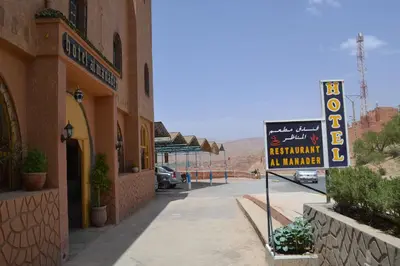 a sign in front of a building next to a sign gmaxwell gmaxwell gmaxwell at Hotel Almanader in Boumalne