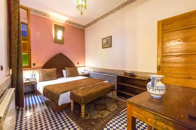 a bedroom with a bed and a table in a room at Riad Al Makan Fes & Spa in Fès