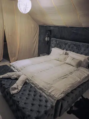 a large bed in a room with a canopy at The Luxury ERG Safari Camp in Merzouga