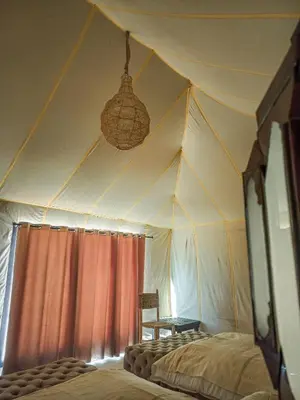 a room with a tent with a bed in it at The Luxury ERG Safari Camp in Merzouga