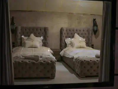 a bedroom with two beds and a mirror at The Luxury ERG Safari Camp in Merzouga