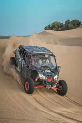 a jeep driving through the sand in the desert at The Luxury ERG Safari Camp in Merzouga