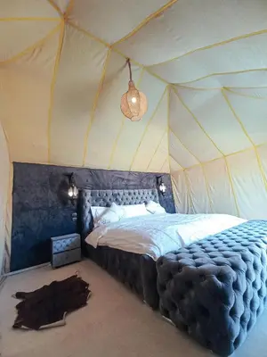 a bedroom with a large bed in a tent at The Luxury ERG Safari Camp in Merzouga