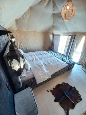 a bedroom with a bed in a tent at The Luxury ERG Safari Camp in Merzouga