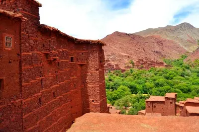 an old brick building with mountains in the background at Dar Megdaz in Megdaz