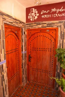 two wooden doors in a room with a sign at Dar Megdaz in Megdaz