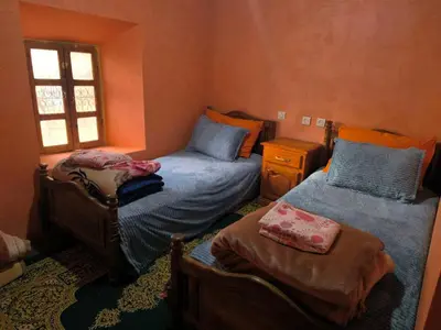 a bedroom with two twin beds and a window at Dar Megdaz in Megdaz