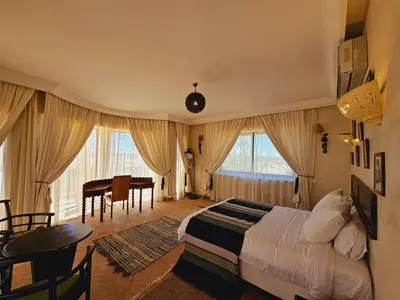 a bedroom with a bed and a table and a desk at villa blanche Marrakech in Marrakech