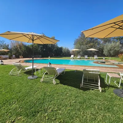 a group of chairs and umbrellas next to a pool at villa blanche Marrakech in Marrakech