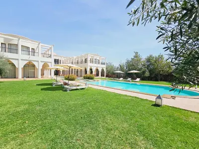 a large house with a swimming pool in a yard at villa blanche Marrakech in Marrakech