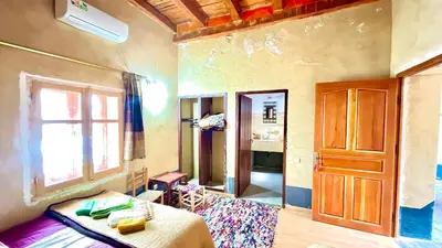 a room with a bed and a window and a door at Kasbah Citoyenne in Agoudal