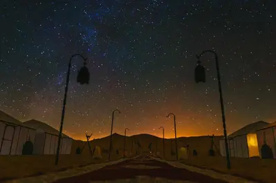 a starry night with street lights and a star filled sky at Sanmao Royal Camp \u7687\u5bb6\u8425\u5730 in Merzouga